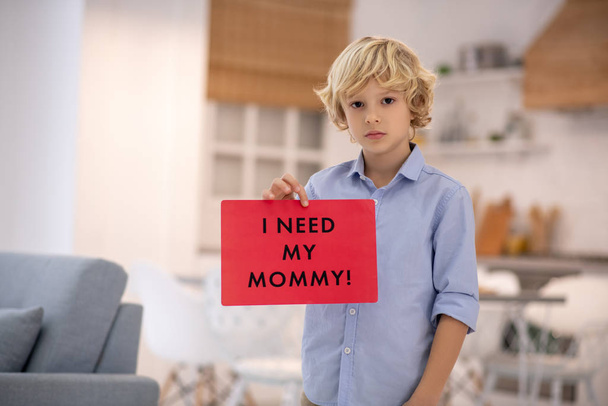 Boy holding sign, feeling upset and missing his mommy - Foto, afbeelding