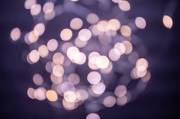 The background is a golden bokeh of the glare of garland lights. Defocus - Photo, Image