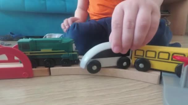 Three years old child boy play with train, build toy railroad at home. - Video