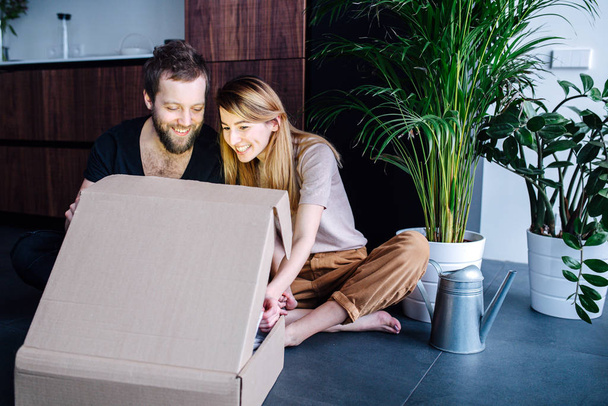 Happy couple looking inside a box, glowing from inside - Photo, image