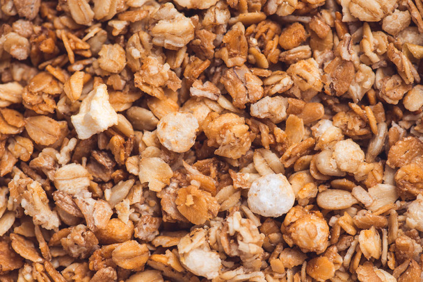 Useful and tasty muesli with nuts, rasins and flakes. Selective focus macro shot with very shallow depth of field. Healthy and vegetarian lifestyle - Fotoğraf, Görsel