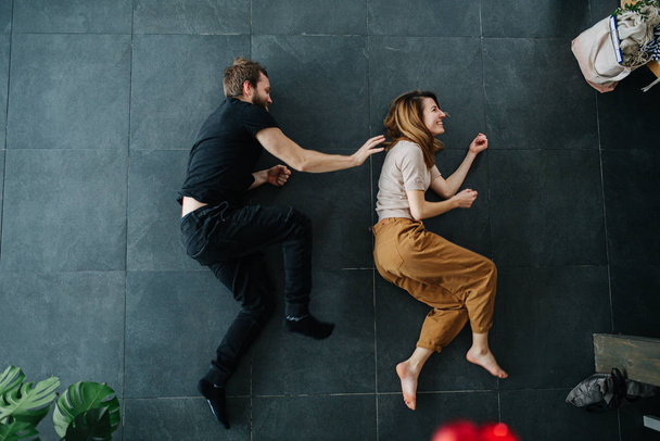 Man and woman depict running while lying on the floor - Foto, Imagem