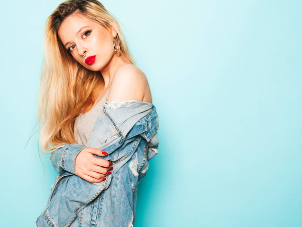 Portrait of young beautiful hipster bad girl in trendy jeans summer clothes and earring in her nose.Sexy carefree smiling blond woman posing in studio.Positive model having fun - Φωτογραφία, εικόνα