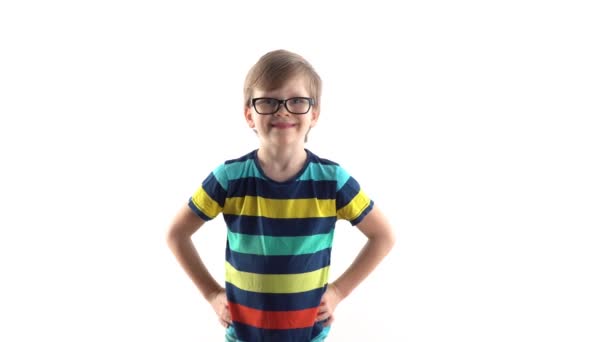 studio portret uśmiechniętego chłopca na białym tle. pierwsza klasa z okularami - Materiał filmowy, wideo