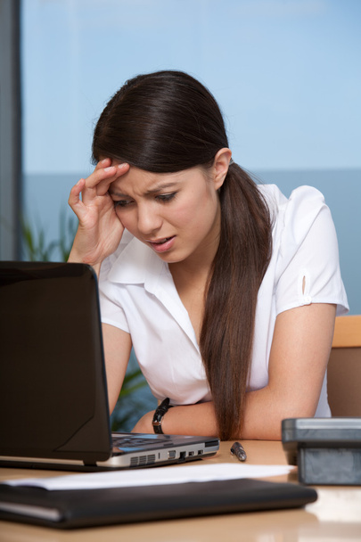 Turhautunut nuori nainen käyttää kannettavaa tietokonetta
 - Valokuva, kuva