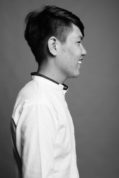 Estúdio tiro de jovem adolescente asiático contra fundo cinza em preto e branco - Foto, Imagem