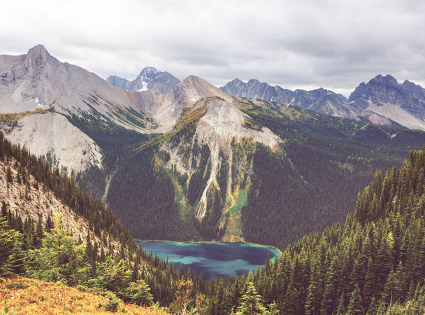 Сцена Сережи у горного озера в Канаде с обвалом скал в спокойной воде. - Фото, изображение