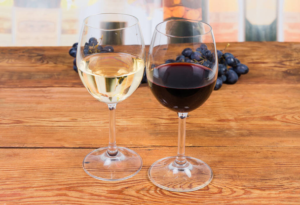 Два бокала красного и белого вина на деревенском столе
 - Фото, изображение