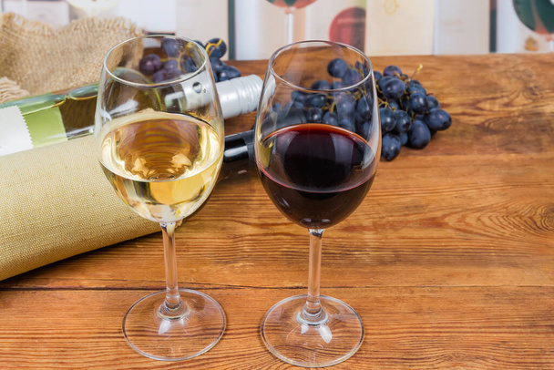 Dos copas de vino tinto y blanco sobre mesa rústica
 - Foto, Imagen