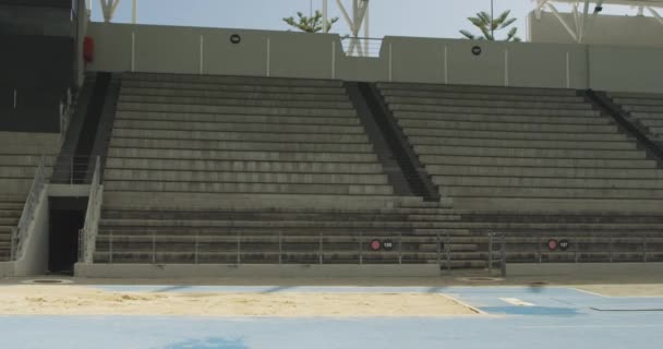 Side view of a mixed race male athlete practicing at a sports stadium, doing long jump, slow motion. Track and Field Sports Training in Stadium. - Footage, Video