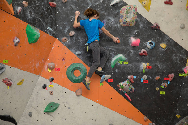 Menino na parede de escalada, Bouldersport, menino escalando uma parede de rocha interior
 - Foto, Imagem