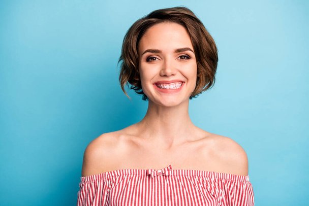 Closeup photo of beautiful pretty lady short bob hairdo positive good mood easy-going person wear pink white striped shirt naked shoulders isolated blue color background - Fotó, kép