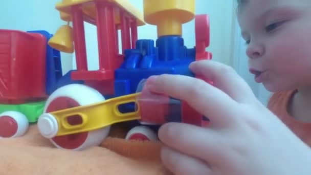 Three years old child boy play with train, build toy railroad at home. - 映像、動画