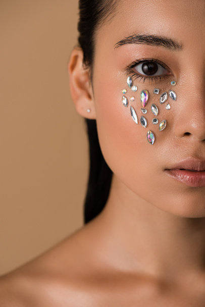 cropped view of beautiful naked asian girl with rhinestones on face isolated on beige - Zdjęcie, obraz