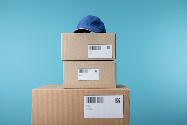 Tapa en cajas de cartón apiladas aisladas en azul
 - Foto, Imagen