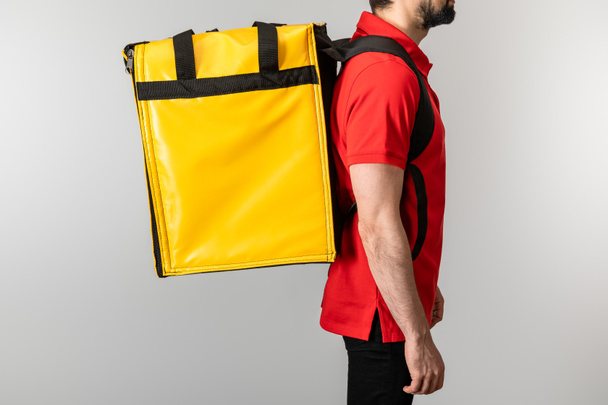 Cropped view of delivery man in uniform with thermo bag isolated on grey - Photo, Image