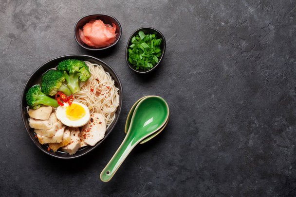 Zuppa di ramen di noodle asiatico con pollo, verdure e uova su sfondo di pietra. Vista dall'alto posa piatta con spazio di copia - Foto, immagini