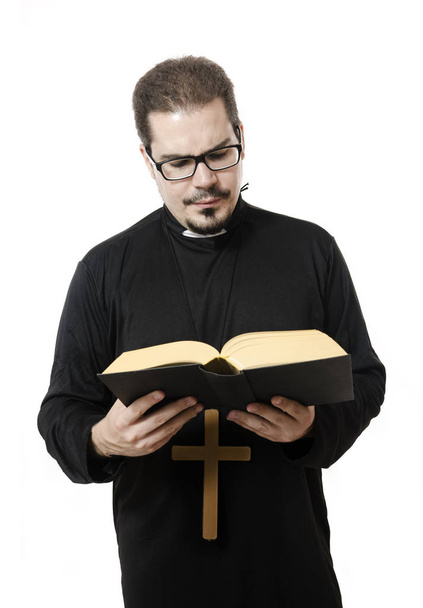 Isolated young priest reading the bible - Photo, Image
