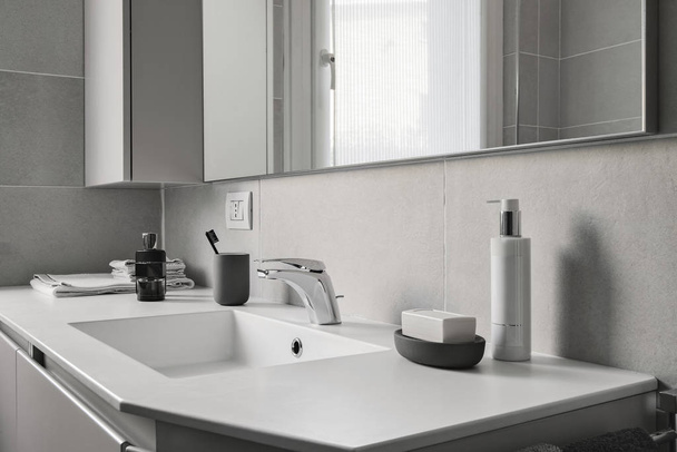 interior shot of a modern bathroom in foreground the integrated washbasin with faucet - Foto, afbeelding