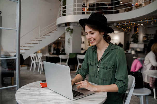 Mulher viajante hipster trabalhar remotamente no café em seu tempo de viagem. Freelancer, empresário, trabalhar no espaço cowering, lugar público, estilo de vida de pessoas modernas, conceito de negócios on-line
. - Foto, Imagem