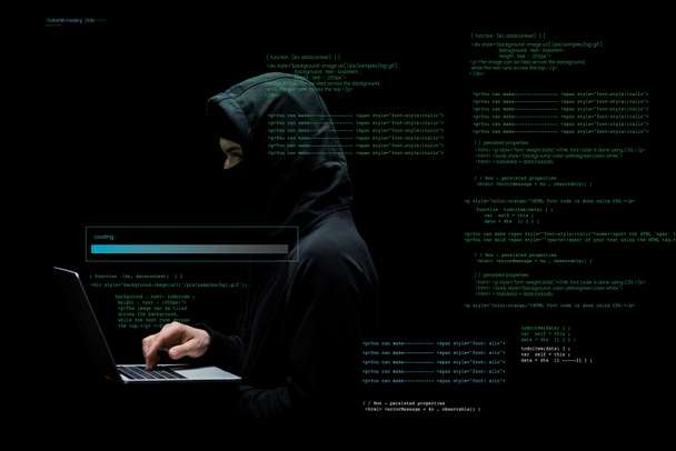 hacker anônimo no capuz e máscara usando laptop perto de dados em preto
  - Foto, Imagem