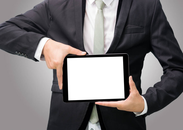 Businessman standing posture hand holding blank tablet isolated on over gray background - Fotografie, Obrázek