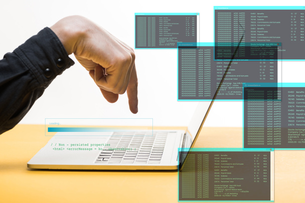 przycięty widok hakera wskazującego palcem na laptopa w pobliżu ilustracji danych na temat białego, koncepcji bezpieczeństwa cybernetycznego - Zdjęcie, obraz
