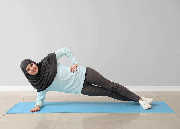 Sportowa muzułmanka ćwicząca jogę na siłowni - Zdjęcie, obraz