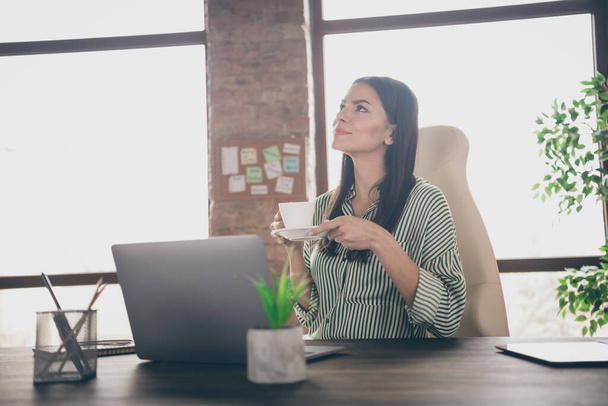 Portrait of her she nice attractive confident cheerful creative dreamy lady successful expert researcher IT recruiter drinking coffee at modern industrial brick loft interior style work place station - 写真・画像