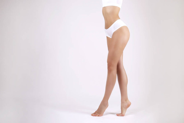 Beyaz sutyen ve yüksek bel külotlu spor bir kadının kırpılmış görüntüsü.. - Fotoğraf, Görsel