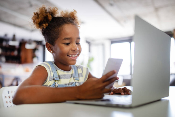 Boldog gyerekek töltenek időt a notebook és a modern technológia. Játék, tanulmány, szórakoztató koncepció - Fotó, kép