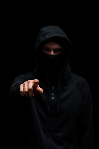 selective focus of hacker in hood pointing with finger isolated on black  - Photo, Image