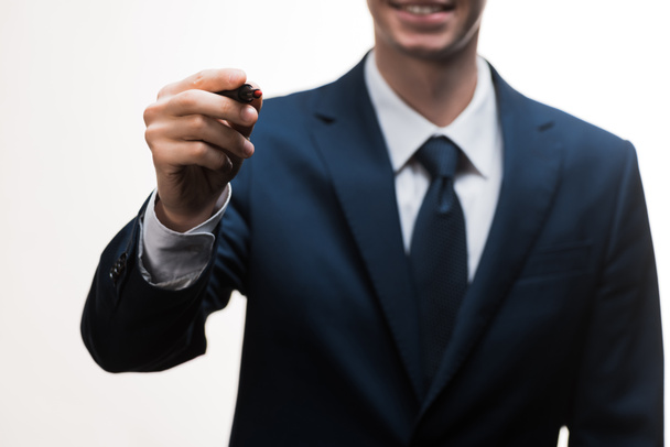 вибірковий фокус щасливого бізнесмена в костюмі тримає маркерну ручку ізольовано на білому
  - Фото, зображення