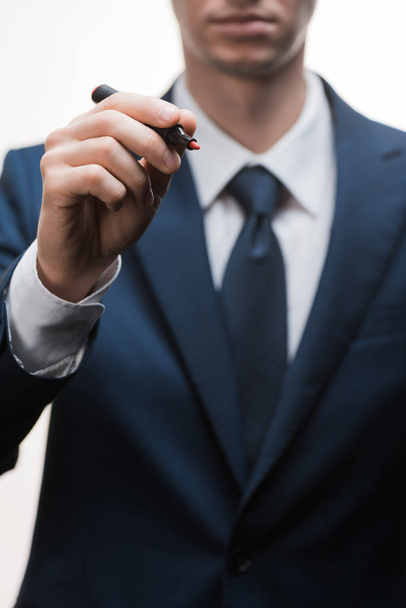 selective focus of businessman in formal wear holding marker pen isolated on white  - Foto, Imagem