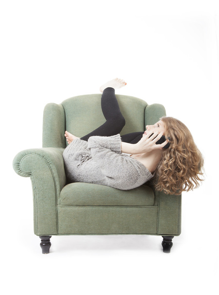young pretty woman on the phone in armchair - Foto, afbeelding