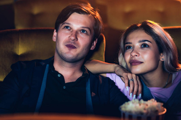 Caucasian lover enjoying to watch movie and eating popcorn together in the cinema - Foto, imagen
