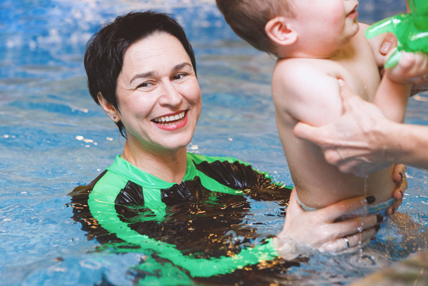 Mujer y niño nadan en la piscina de agua
. - Foto, imagen