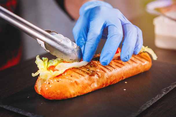 Chef is cooking a hot dog. - Zdjęcie, obraz