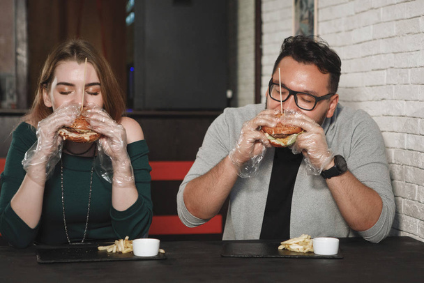 Пара їсть бургер
 - Фото, зображення