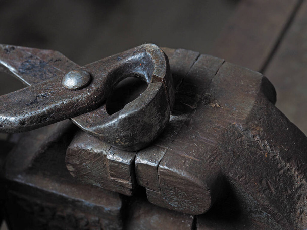 Old metal wire cutters lie on a rusty vise. The concept of working tools - Photo, Image