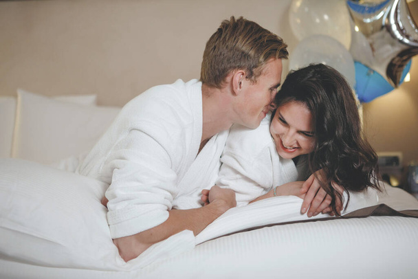 Весела пара прокидається і дивиться один на одного в ліжку
 - Фото, зображення