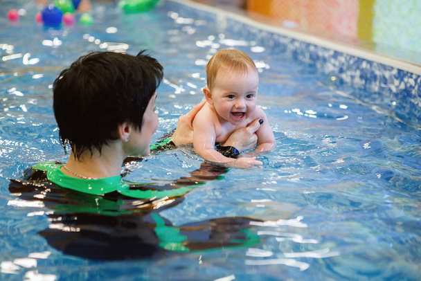 Female and child swim in water pool. - Photo, Image