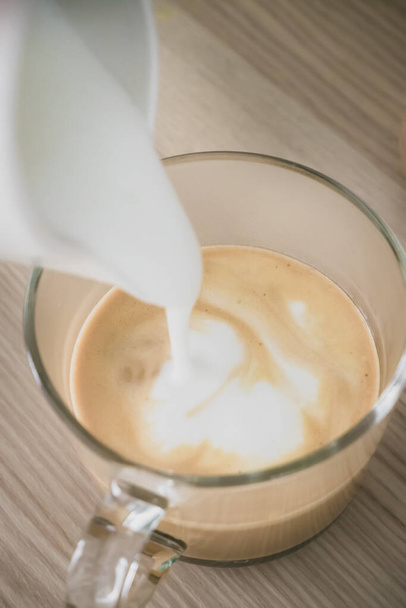 Mléčná pěna se vlévá do kávy. - Fotografie, Obrázek