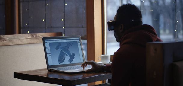 カフェでノートパソコンで作業するグラフィックデザイナー - 写真・画像