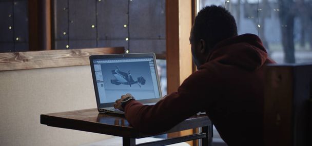 Grafisch ontwerper werkt op een laptop in een café - Foto, afbeelding