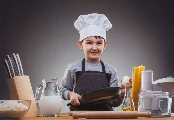Boy Chef Cooking on a gray background. - Фото, изображение