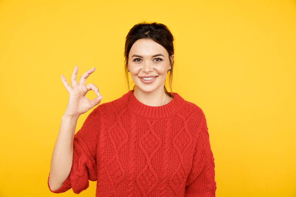 Happy woman showing ok isolated on the bright yellow background. - Photo, Image