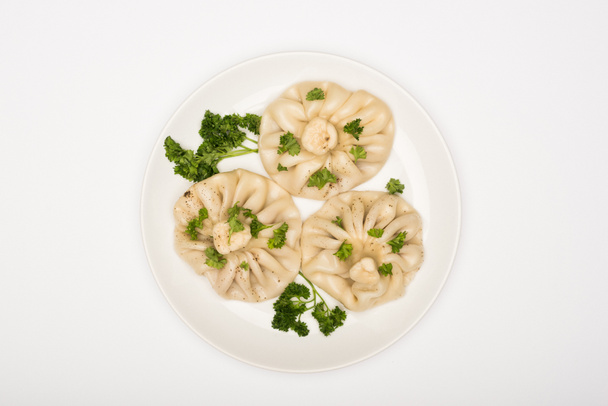 top view of delicious Khinkali with cilantro on plate on white background - 写真・画像