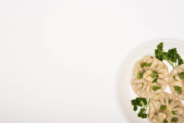 felső kilátás ízletes Khinkali cilantro tányéron fehér háttér - Fotó, kép