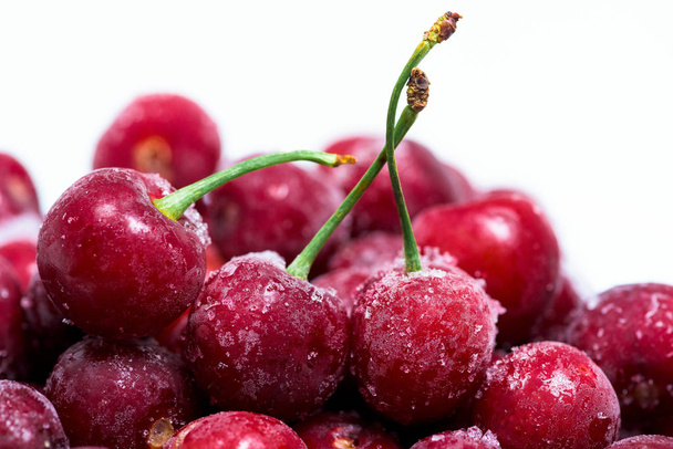 group of frozen cherries on a white background . close-up of berries. ice crystals on the fruit - Photo, image